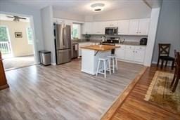 185 Baldwinville Rd, Winchendon, MA 01475 - kitchen featuring stainless steel appliances, white cabinetry, a breakfast bar, and dark wood-type flooring
