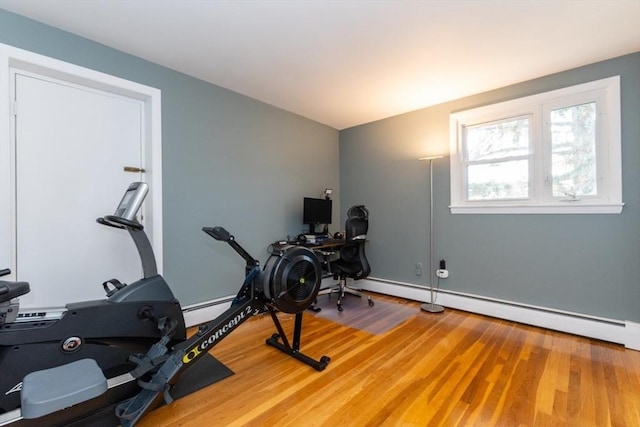 interior space featuring a baseboard heating unit and wood finished floors