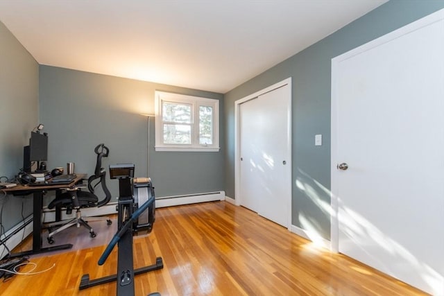 office space with a baseboard heating unit and wood finished floors