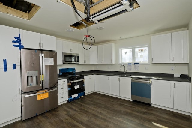 205 Clemente St, Holyoke, MA 01040 - kitchen with stainless steel appliances, dark countertops, dark wood-style floors, and white cabinets
