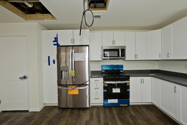 205 Clemente St, Holyoke, MA 01040 - kitchen with stainless steel appliances, dark countertops, dark wood-style floors, and white cabinets