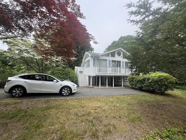 18 Blueberry Ln, Barnstable, MA 02648 - back of house with driveway, stairway, and a lawn