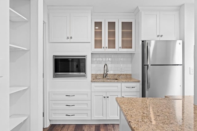 35 Des Moines Rd Unit 310, Quincy, MA 02169 - kitchen with freestanding refrigerator, built in microwave, white cabinetry, glass insert cabinets, and light stone countertops