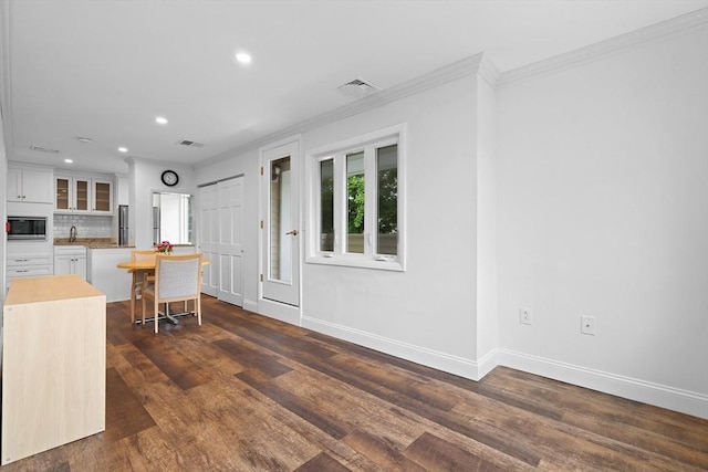 35 Des Moines Rd Unit 310, Quincy, MA 02169 - kitchen with stainless steel microwave, ornamental molding, recessed lighting, glass insert cabinets, and dark wood-style flooring