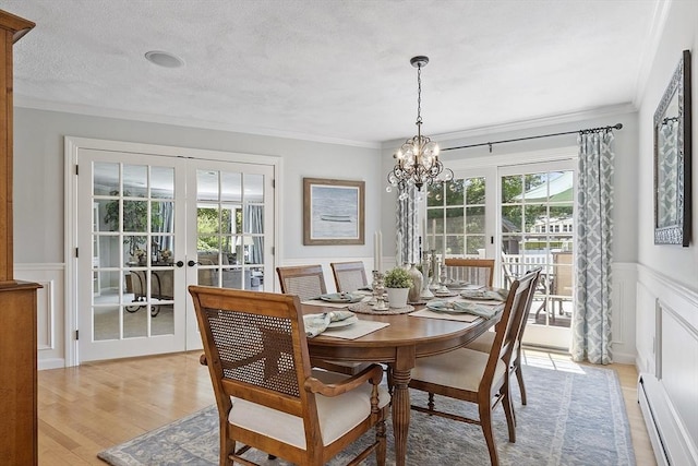 9 Bateson Dr, Andover, MA 01810 - dining space with a baseboard heating unit, french doors, a chandelier, wainscoting, and crown molding