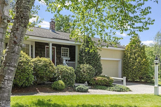9 Bateson Dr, Andover, MA 01810 - view of front of house featuring an attached garage, a chimney, a shingled roof, and covered porch
