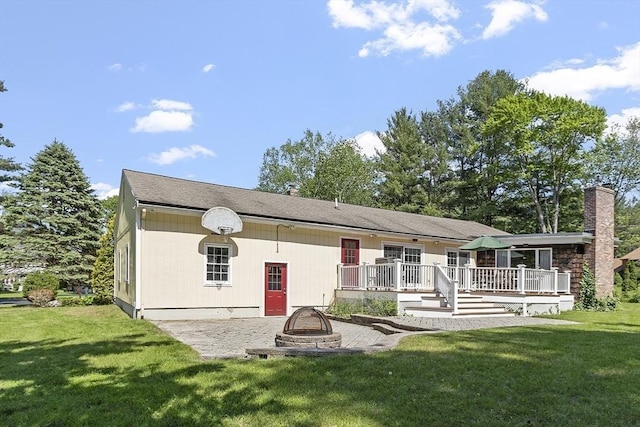 9 Bateson Dr, Andover, MA 01810 - back of property with an outdoor fire pit, a deck, a yard, and a chimney