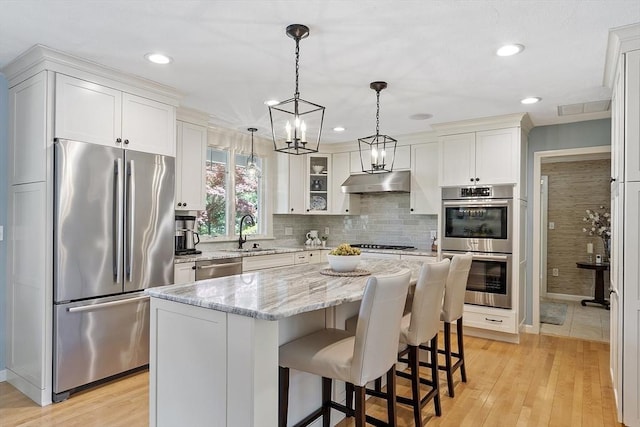 9 Bateson Dr, Andover, MA 01810 - kitchen featuring stainless steel appliances, under cabinet range hood, a sink, white cabinetry, and recessed lighting
