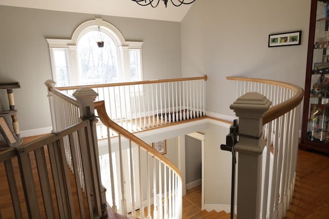 staircase with lofted ceiling and a chandelier