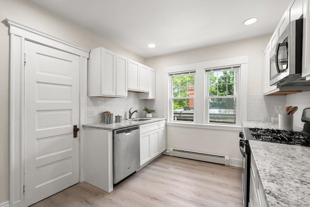 3 Regent Cir Unit 3, Boston, MA 02130 - kitchen with appliances with stainless steel finishes, a baseboard radiator, white cabinets, tasteful backsplash, and light wood finished floors
