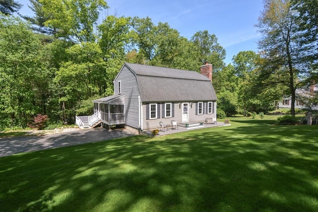 33 Rockmeadow Rd, Uxbridge, MA 01569 - view of front of house with a sunroom, a gambrel roof, a chimney, a front yard, and roof with shingles
