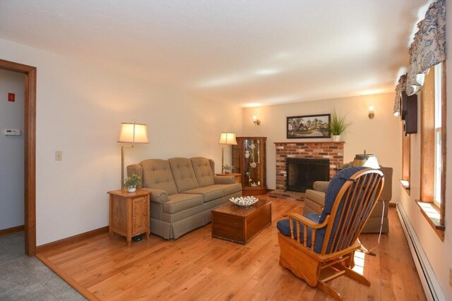 33 Rockmeadow Rd, Uxbridge, MA 01569 - living room with a baseboard radiator, a brick fireplace, light wood-style flooring, and baseboards