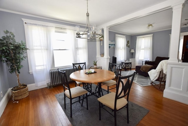 419-421 Court St, New Bedford, MA 02740 - dining space with ornate columns, radiator heating unit, wood finished floors, crown molding, and baseboards