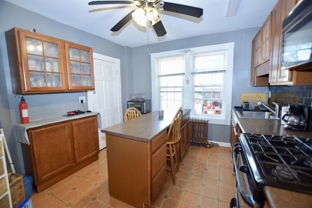 419-421 Court St, New Bedford, MA 02740 - kitchen with radiator heating unit, a peninsula, black microwave, a ceiling fan, and brown cabinetry