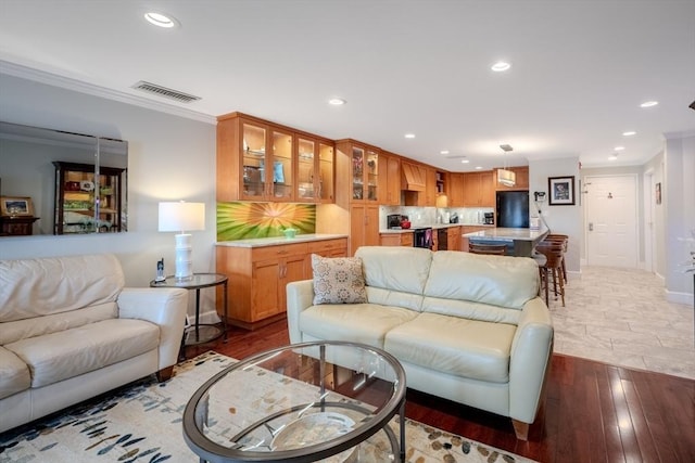 living room featuring wood-type flooring and crown molding