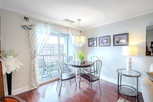 dining space featuring dark wood-type flooring and ornamental molding