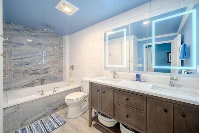 full bathroom with hardwood / wood-style flooring, tiled shower / bath combo, vanity, ornamental molding, and toilet