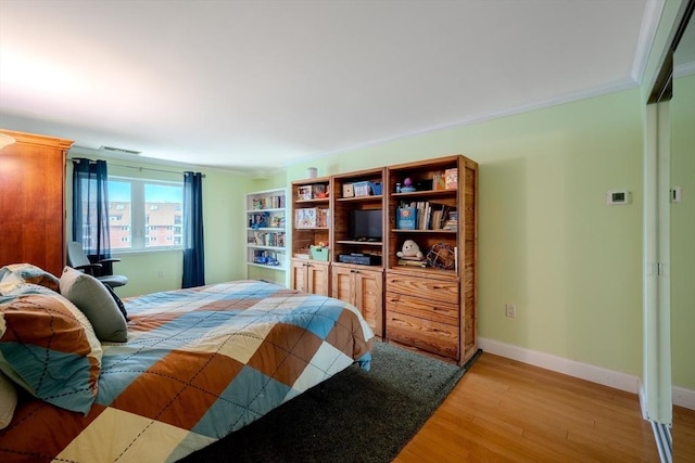 bedroom with hardwood / wood-style flooring and ornamental molding