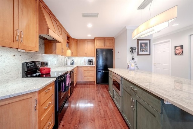 kitchen with sink, light stone counters, tasteful backsplash, decorative light fixtures, and black appliances