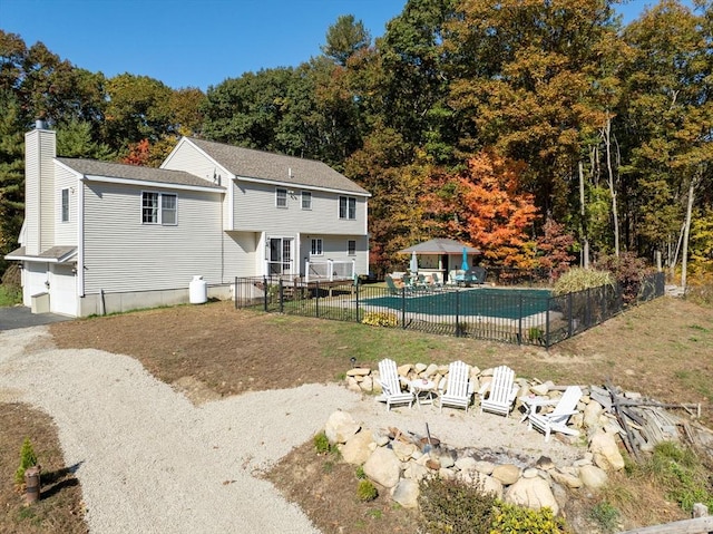 back of house with a fenced in pool