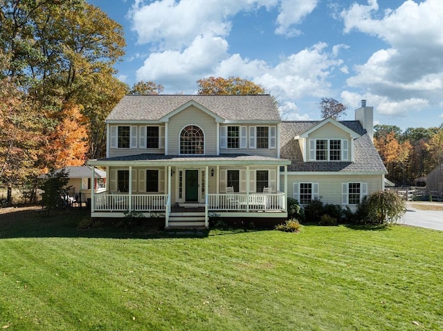 colonial house featuring covered porch and a front lawn