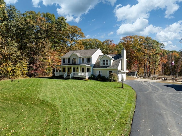 view of front of property with a front yard, a garage, and covered porch