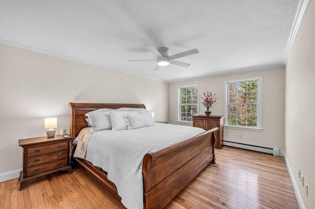 bedroom with crown molding, a baseboard heating unit, ceiling fan, and light hardwood / wood-style flooring