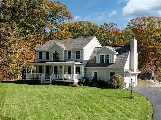 view of front facade with covered porch, a front lawn, and a garage