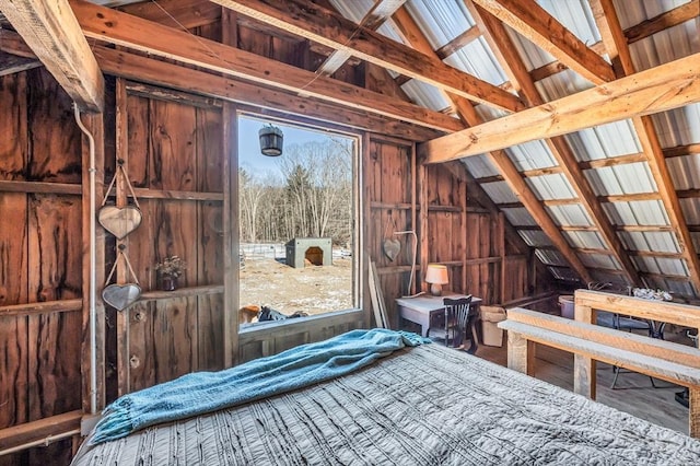 bedroom featuring lofted ceiling, wood-type flooring, and wooden walls