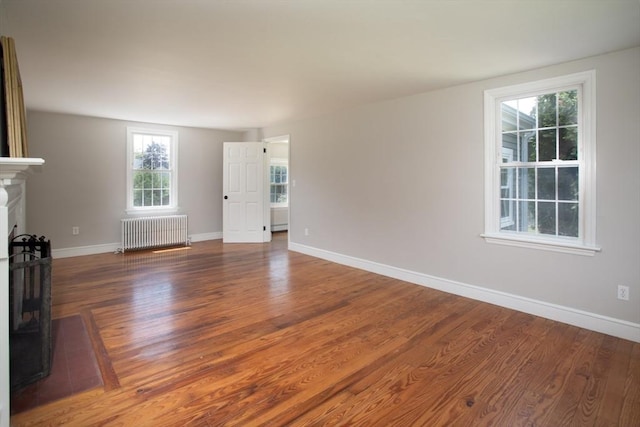 329 Read St, Somerset, MA 02726 - unfurnished living room with radiator, wood finished floors, plenty of natural light, and a fireplace