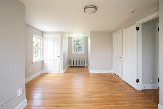 329 Read St, Somerset, MA 02726 - unfurnished bedroom with radiator heating unit, light wood-type flooring, and multiple closets