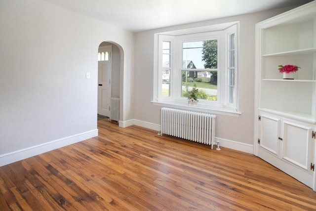 329 Read St, Somerset, MA 02726 - unfurnished room with radiator heating unit, arched walkways, and plenty of natural light