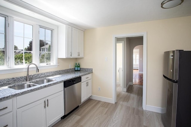 329 Read St, Somerset, MA 02726 - kitchen with appliances with stainless steel finishes, arched walkways, light wood-style floors, and light stone countertops