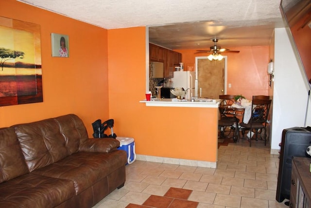 living area with a textured ceiling and a ceiling fan