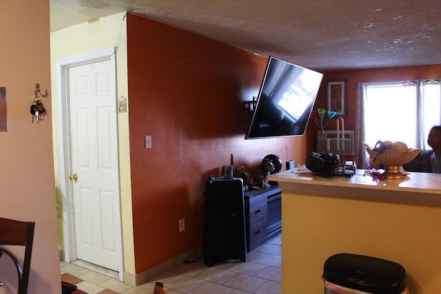 interior space featuring a textured ceiling and light tile patterned floors