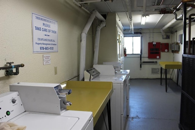 common laundry area featuring a textured wall and washer and clothes dryer