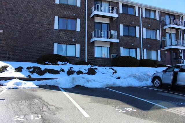 snow covered property with uncovered parking