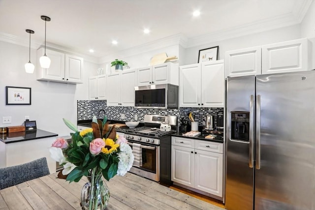 kitchen featuring tasteful backsplash, ornamental molding, appliances with stainless steel finishes, and white cabinets