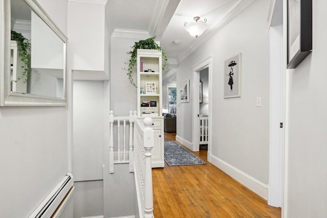 hallway with ornamental molding, light hardwood / wood-style floors, and a baseboard heating unit