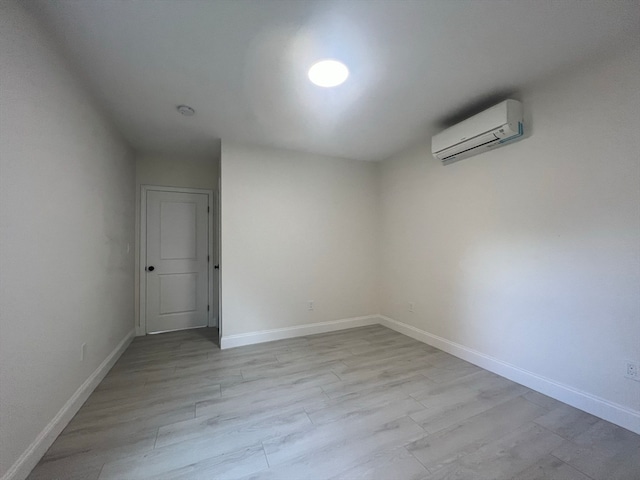 empty room with light hardwood / wood-style floors and a wall unit AC