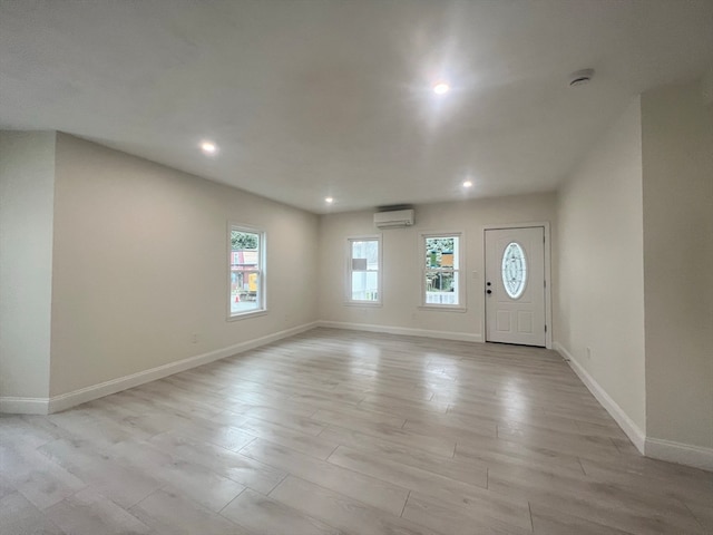 foyer featuring light hardwood / wood-style floors and a wall mounted AC