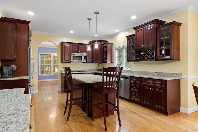 1 Eleanor Dr, Wilmington, MA 01887 - kitchen with appliances with stainless steel finishes, arched walkways, light wood-type flooring, hanging light fixtures, and crown molding