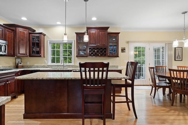 1 Eleanor Dr, Wilmington, MA 01887 - kitchen featuring ornamental molding, a sink, a kitchen island, hanging light fixtures, and a kitchen bar