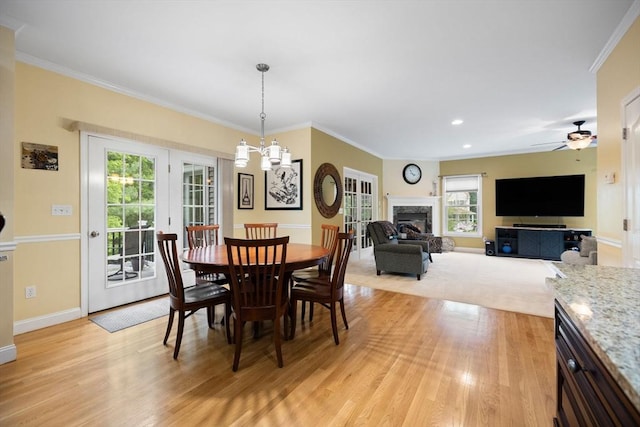 1 Eleanor Dr, Wilmington, MA 01887 - dining space featuring healthy amount of natural light, light wood finished floors, baseboards, a glass covered fireplace, and ornamental molding