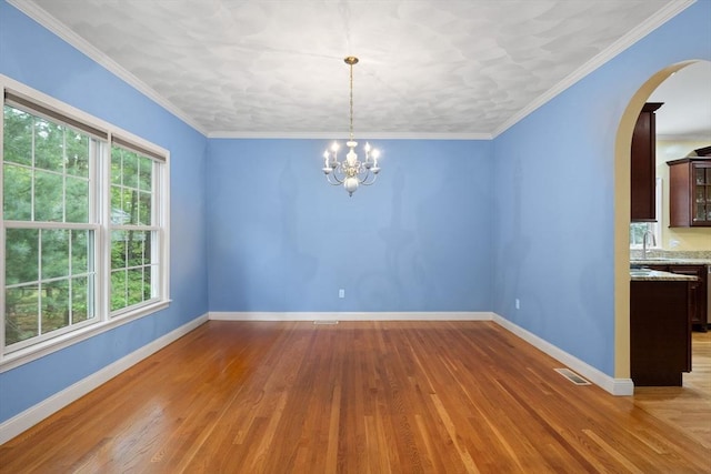 1 Eleanor Dr, Wilmington, MA 01887 - spare room featuring arched walkways, a chandelier, wood finished floors, and baseboards
