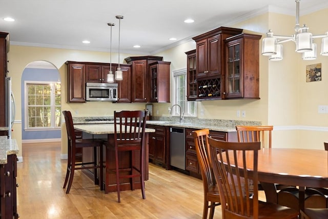 1 Eleanor Dr, Wilmington, MA 01887 - kitchen featuring stainless steel appliances, light wood-type flooring, glass insert cabinets, decorative light fixtures, and arched walkways