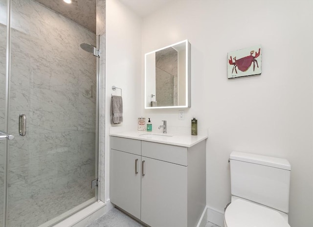 bathroom featuring toilet, vanity, and a shower with door