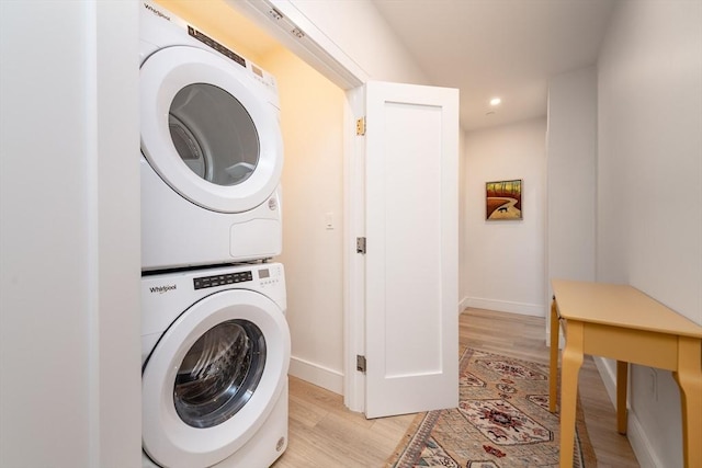 laundry area with stacked washing maching and dryer and light wood-type flooring