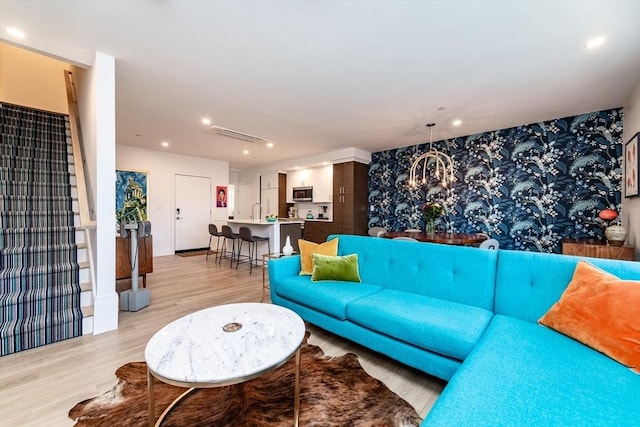 living room with a notable chandelier and light hardwood / wood-style floors