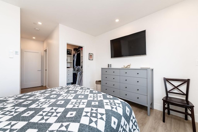 bedroom featuring hardwood / wood-style floors, a closet, and a walk in closet